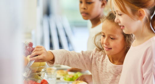Barn tar mat från servering i skolmatsal