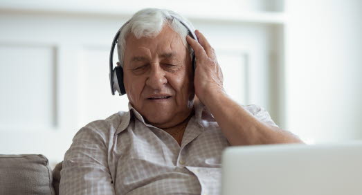 Äldre man med lyssnar i trådlösa hörlurar