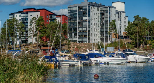 Båthamn med flera båtar, i bakgrunden syns flera lägenhetshus och ett vattentorn