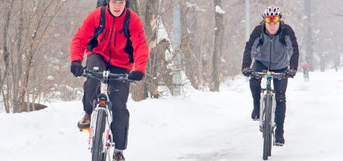 Cyklister cyklar i snön