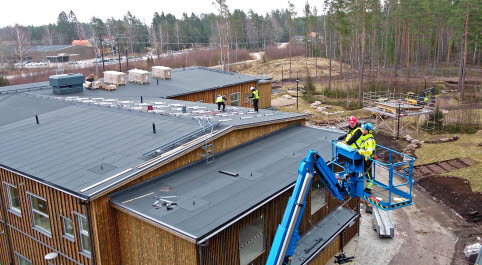 Vy över Annebergs förskola där arbetet pågår med att färdigställa taket och lägga solcellspaneler.