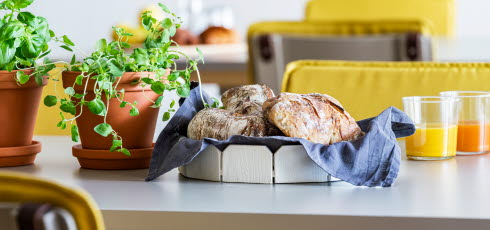 Interiörbild från matsalen på en avdelning på Djupängen. På bilden syns närbild på ett bord där en brödkorg tår framdukad.,
